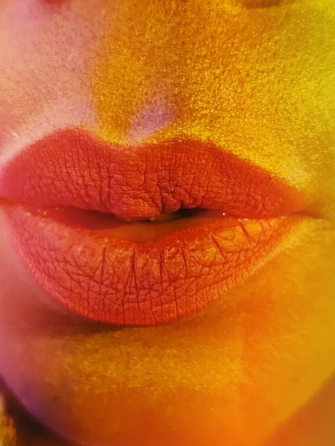 Close beauty portrait in saturated red, orange and yellow light
