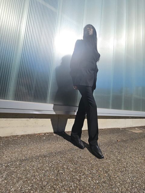 Full-length portrait against translucent architectural panels